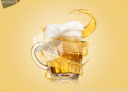 Image of Flying spiral splash around mug of light fresh beer with thick foam.