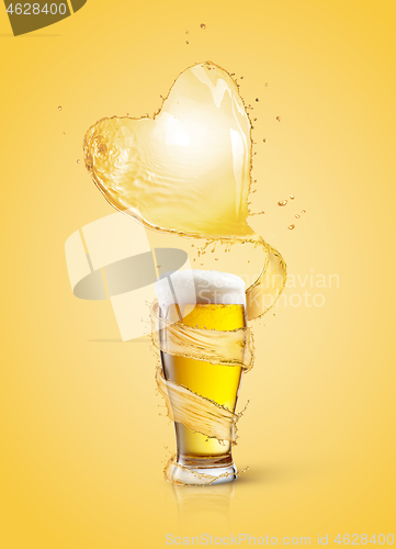 Image of Heart splash of light beer above full glass of fresh beverage.