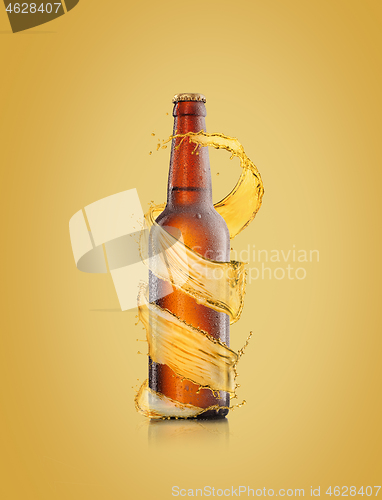 Image of Beer bottle with water drops and spiral splash around bottle.