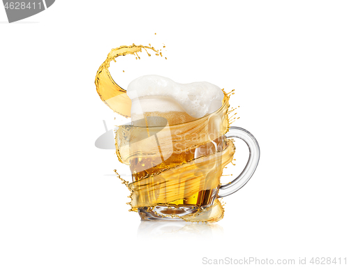 Image of Refreshing beer glass mug with thick foam and flying splash.