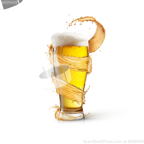 Image of Flying spiral splash around glass of light fresh beer with thick foam.