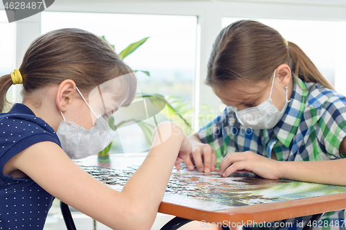 Image of Two girls at home in isolation mode play board games