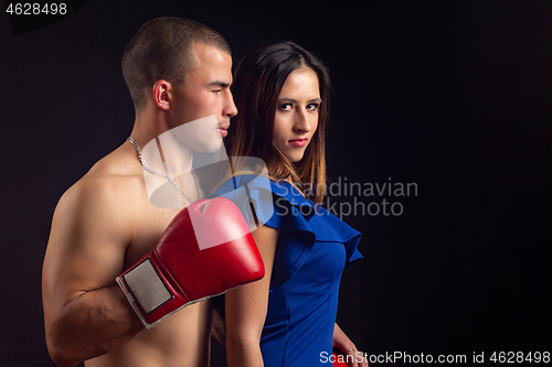 Image of Boxer hugs slender girl on black background