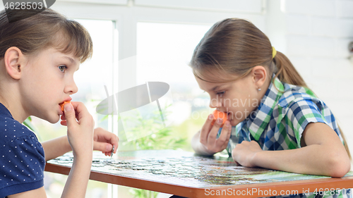 Image of Children collect puzzles and snack on carrots