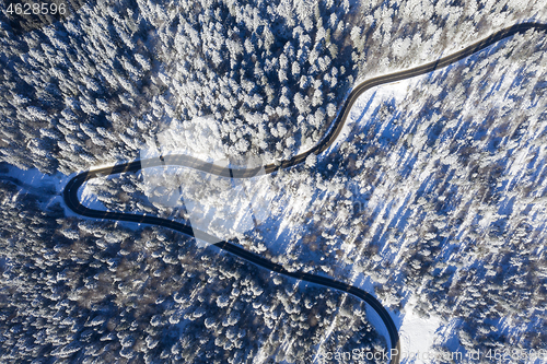 Image of Curvy road in winter forest, view from above