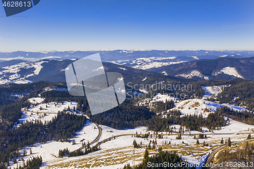 Image of Aerial winter landscape of forests and a curvy road