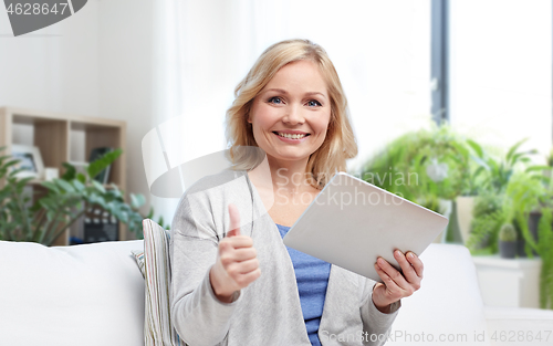 Image of happy woman with tablet pc showing thumbs up