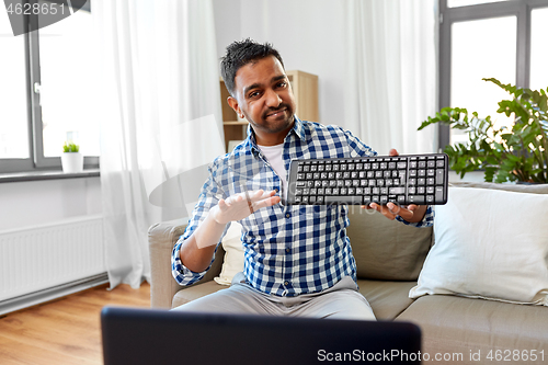 Image of male blogger with keyboard videoblogging at home