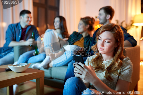 Image of sad young woman with smartphone at home party