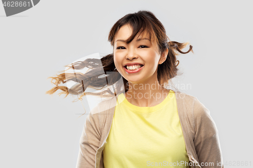 Image of happy asian woman with waving hair