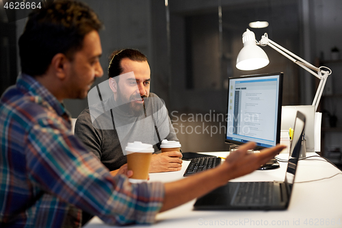 Image of creative team drinking coffee at night office