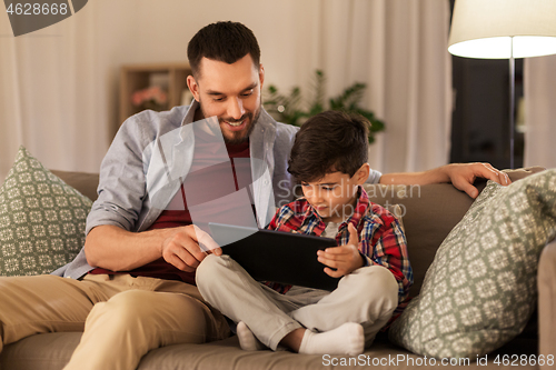 Image of father and son with tablet pc playing at home