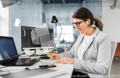 Image of businesswoman with notebook working at office