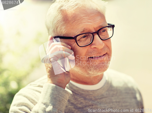 Image of happy senior man calling on smartphone in city