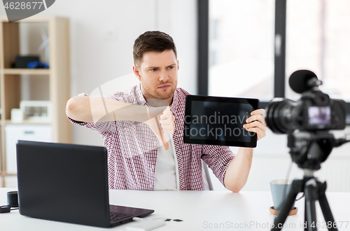 Image of male blogger with tablet computer videoblogging