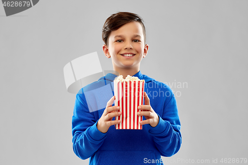 Image of happy smiling boy in blue hoodie with popcorn