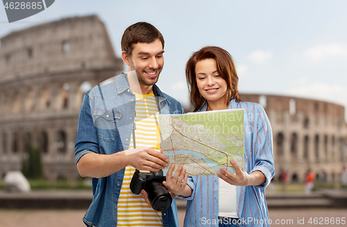 Image of happy couple of tourists with map and camera