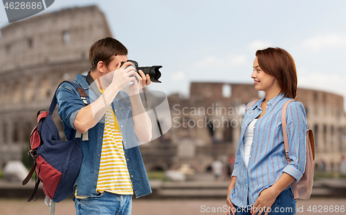 Image of happy couple of tourists with backpacks and camera