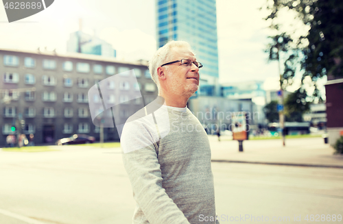 Image of senior man walking along summer city street