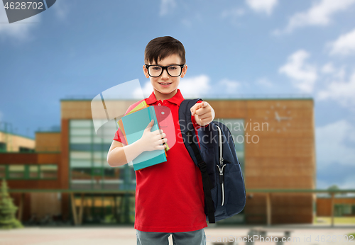 Image of schoolboy with books and bag over school