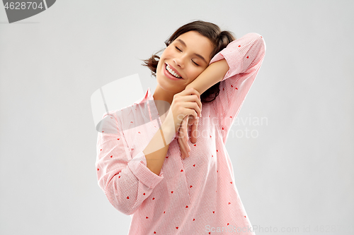 Image of happy woman in pajama making sleeping gesture