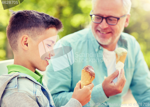 Image of old man and boy eating ice cream at summer park