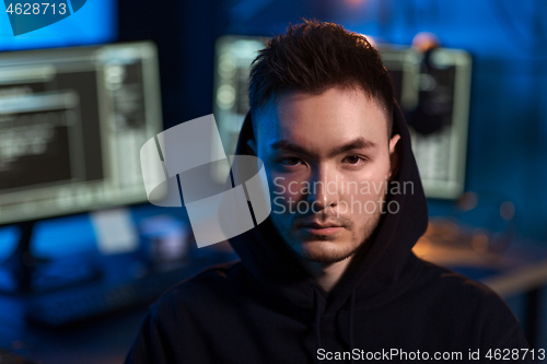 Image of asian hacker in dark room with computers at night