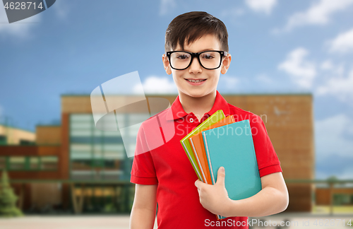 Image of smiling schoolboy in glasses with books
