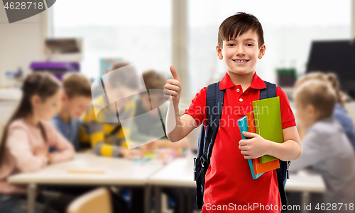 Image of student boy with books and bag showing thumbs up