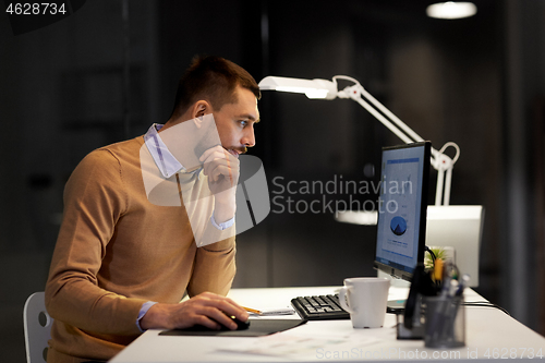 Image of man with computer working late at night office