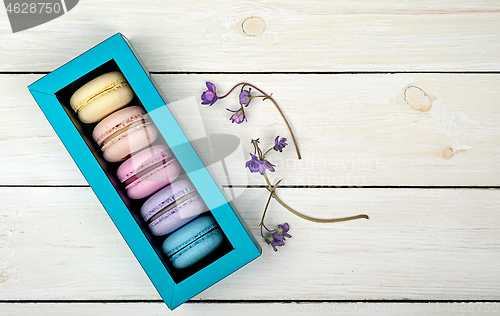 Image of Macaroons in gift box next to violet