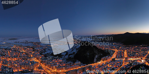 Image of Aerial view after sunset, city lights and mountains