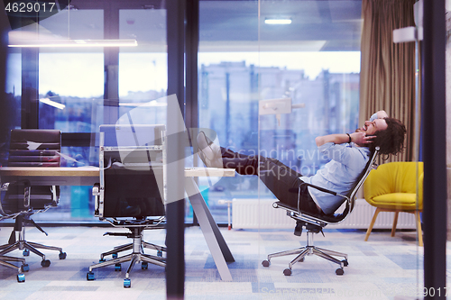 Image of young businessman relaxing at the desk