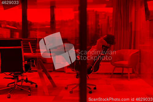 Image of young businessman relaxing at the desk