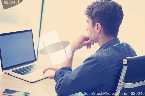 Image of businessman working using a laptop in startup office