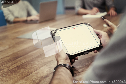 Image of close up of businessman on meeting using tablet