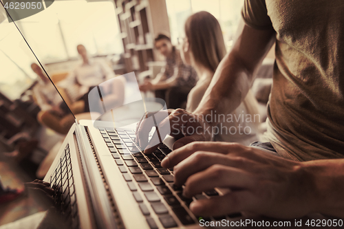 Image of close up of male hands while working on laptop