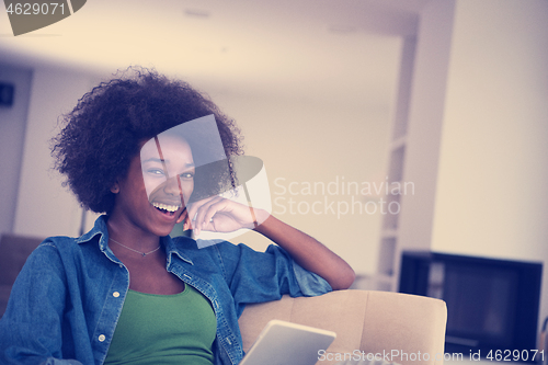 Image of african american woman at home with digital tablet