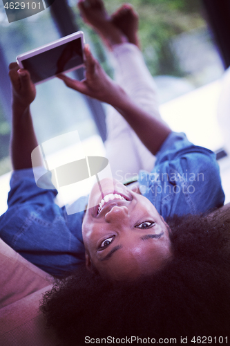 Image of african american woman at home with digital tablet