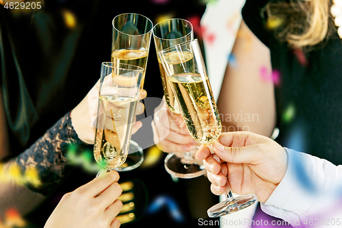 Image of Celebration. Hands holding the glasses of champagne and wine making a toast.