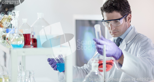 Image of Researcher performing scientific experiment in chemical laboratory.