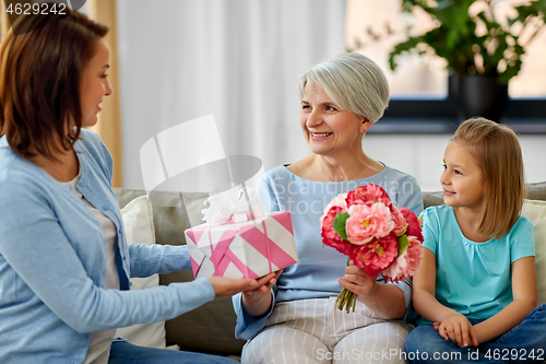 Image of female family giving present to grandmother