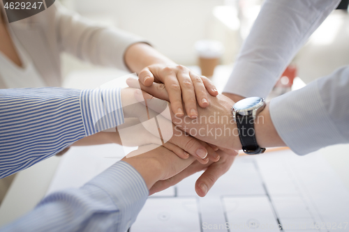 Image of close up of business team stacking hands