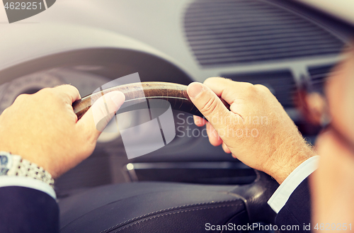 Image of senior businessman hands driving car