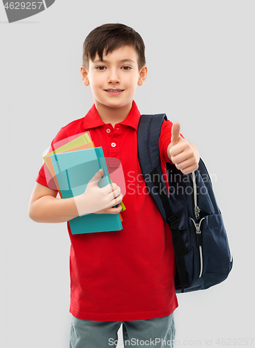 Image of boy with books and school bag showing thumbs up