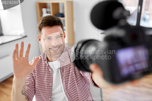 Image of male video blogger with camera blogging at home