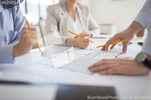 Image of close up of architects with blueprint at office