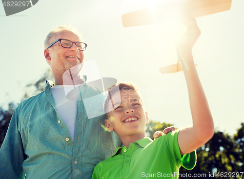 Image of senior man and boy with toy airplane over sky