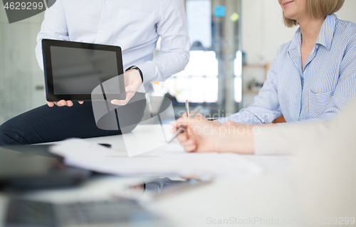 Image of close up of business team with tablet pc at office