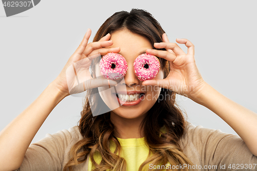 Image of happy asian woman with eyes of donuts